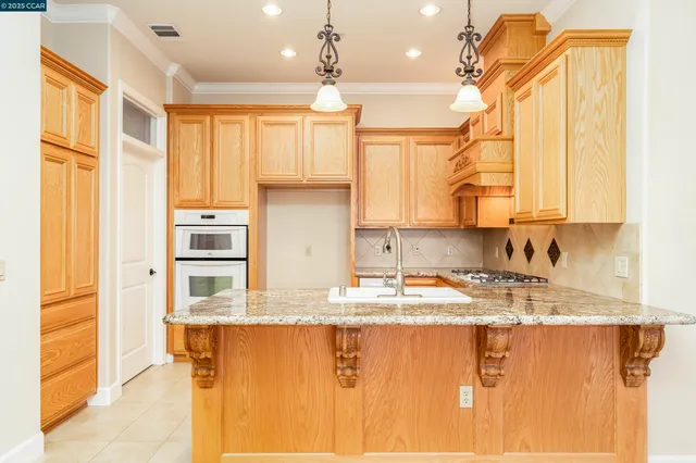 a kitchen with stainless steel appliances granite countertop a sink and cabinets with wooden floor