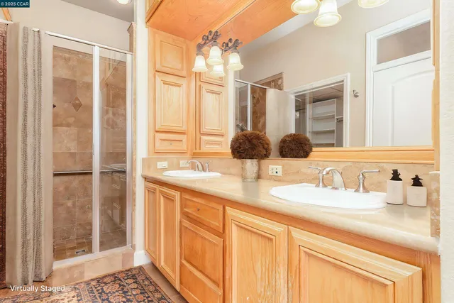 a bathroom with a granite countertop sink a mirror and a shower
