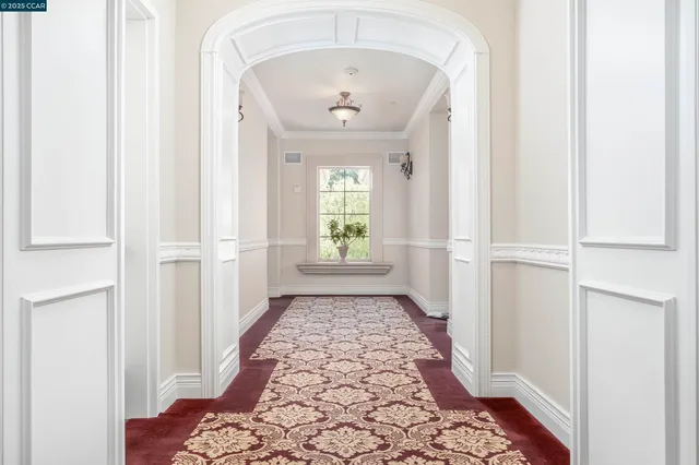 a view of a hallway with wooden floor and a dining room