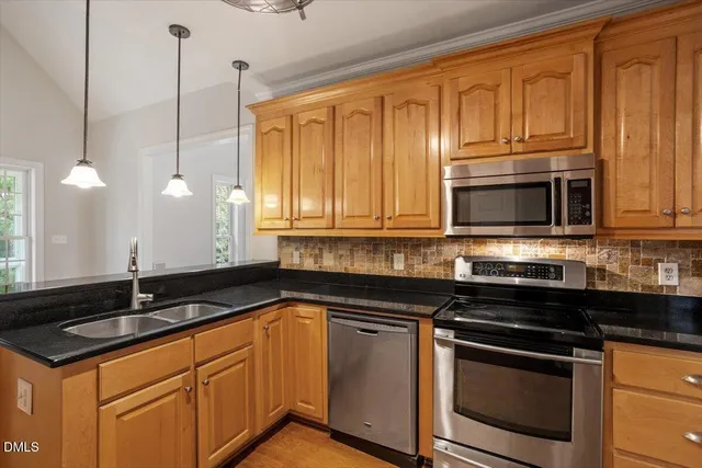 a kitchen with granite countertop a sink stainless steel appliances and cabinets
