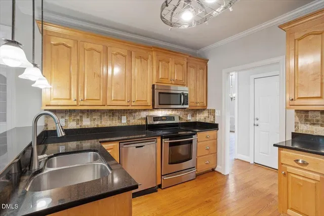 a kitchen with granite countertop a stove sink and microwave
