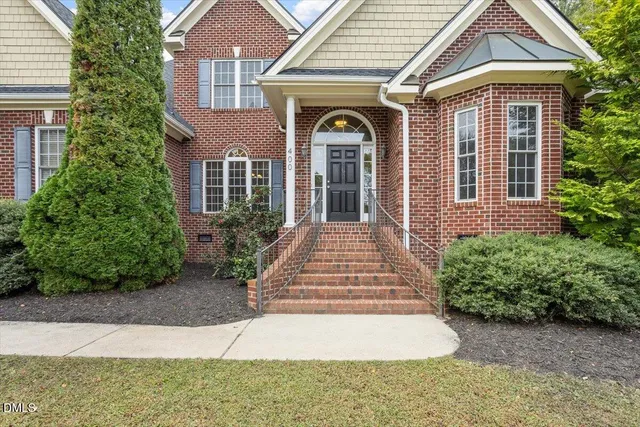 a front view of a house with yard and green space