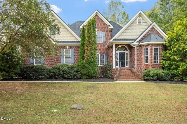 a view of a house with a yard and potted plants