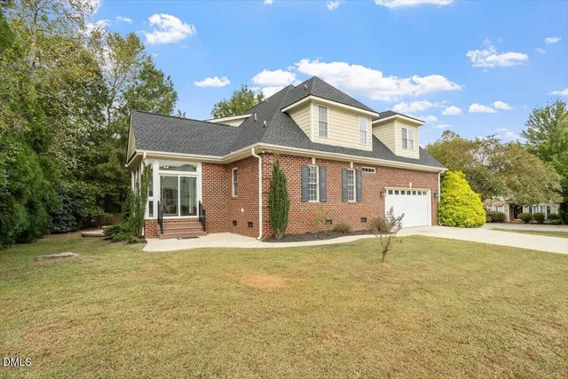 a front view of a house with a garden and yard