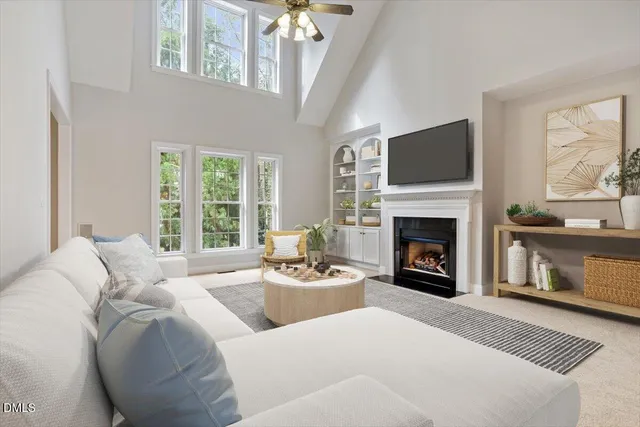 a living room with furniture a fireplace and a large window