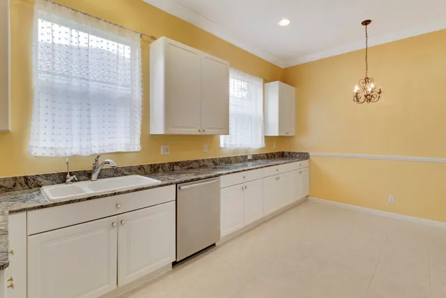 a kitchen with granite countertop a sink a counter top space and cabinets