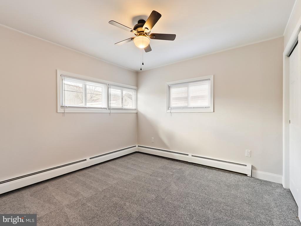 10 Blue Ridge Drive Levittown, PA 19057 - Photo 22 of 31 an empty room with a window and a ceiling fan