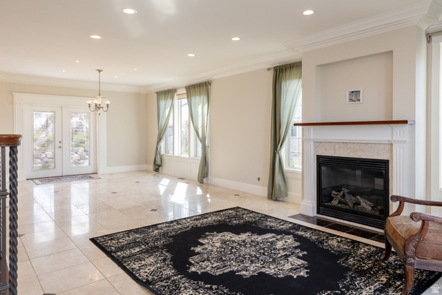 434 Cardon Ridge Drive Smithfield, UT 84335 - Photo 7 of 59 Living room with crown molding, hanging lights, a fireplace with flush hearth, light tile patterned flooring, and french doors