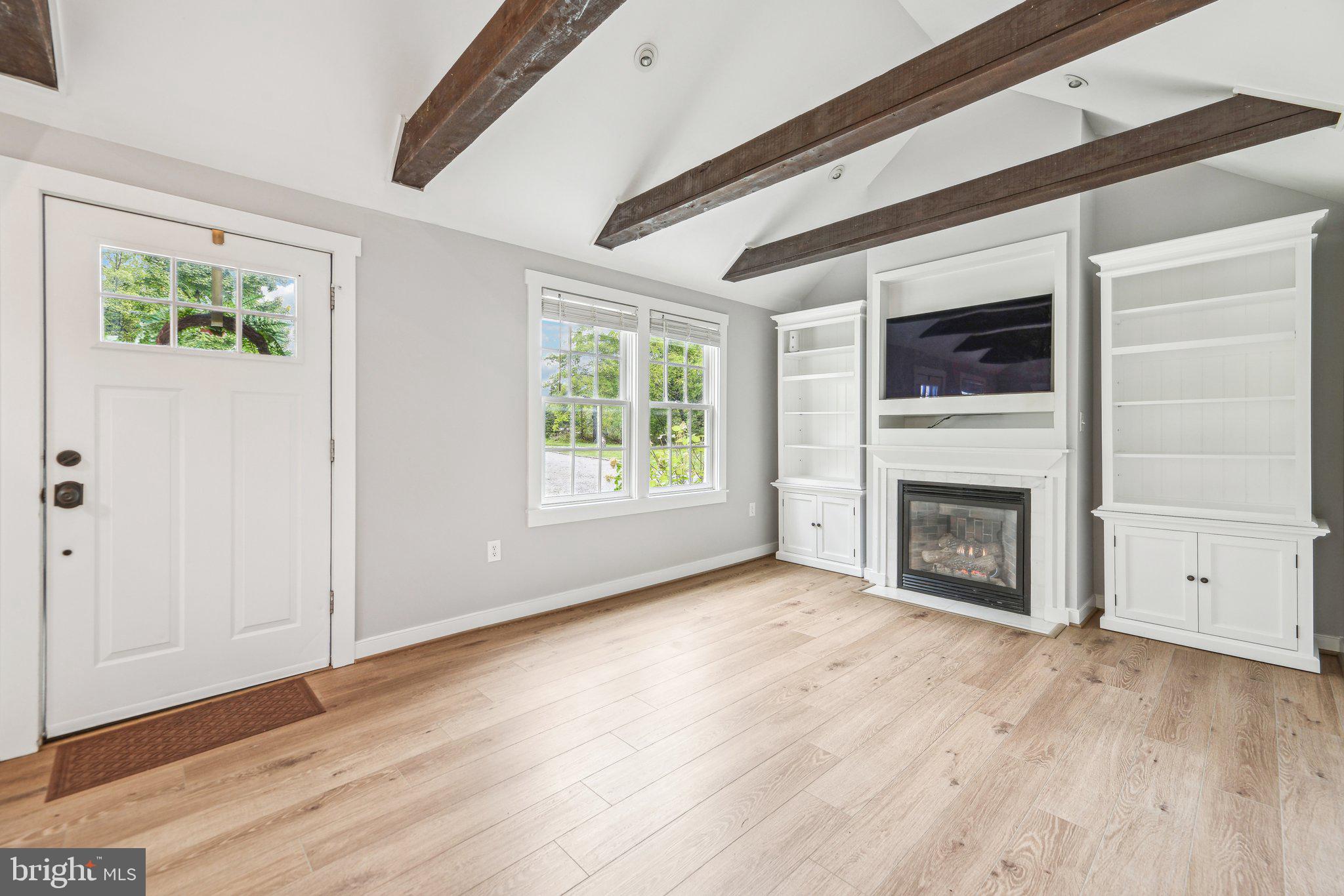 39913 Thomas Mill Road Leesburg, VA 20175 - Photo 16 of 46 an empty room with windows a fireplace and wooden floor