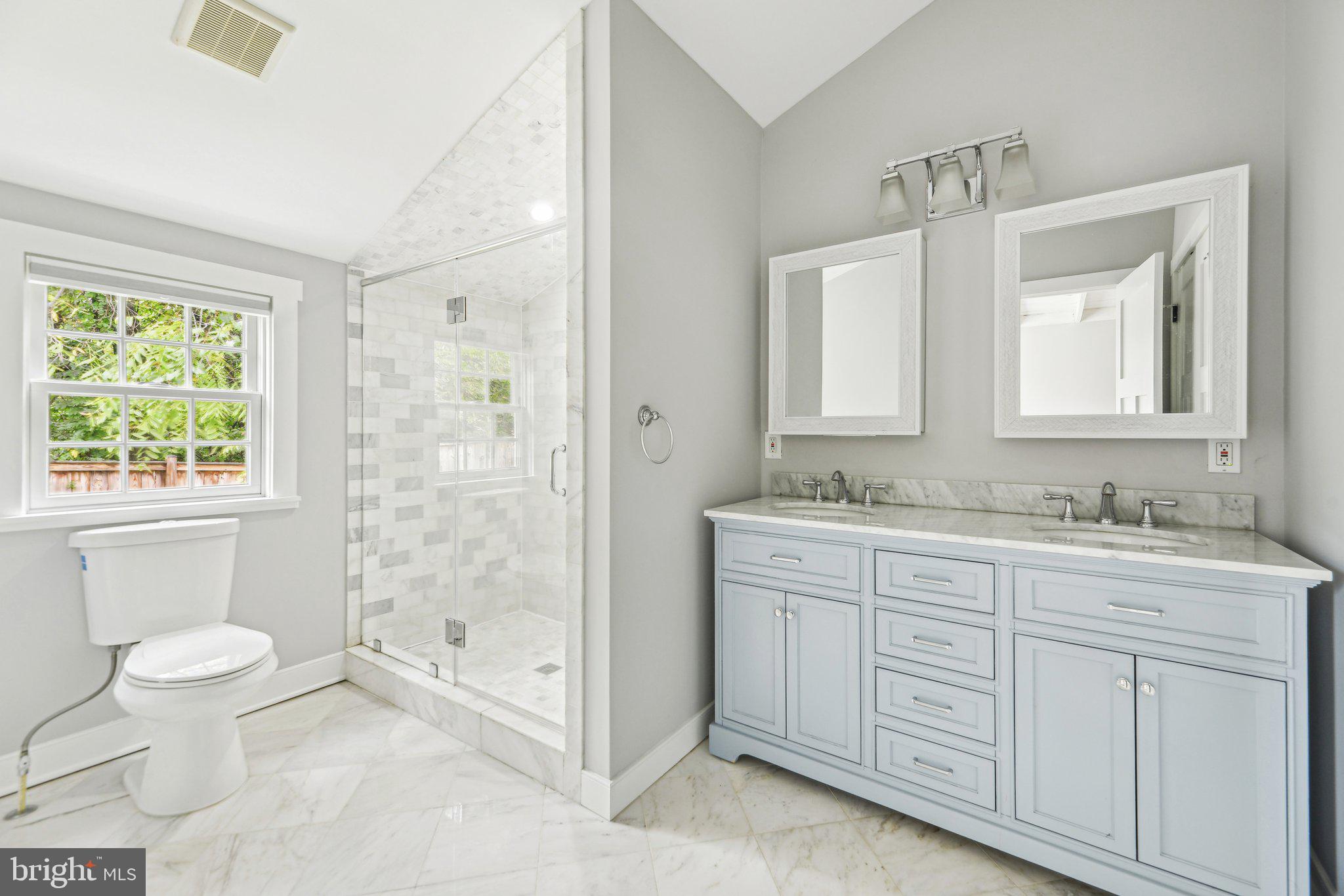 39913 Thomas Mill Road Leesburg, VA 20175 - Photo 34 of 46 a bathroom with a granite countertop sink toilet a large mirror a shower and a window