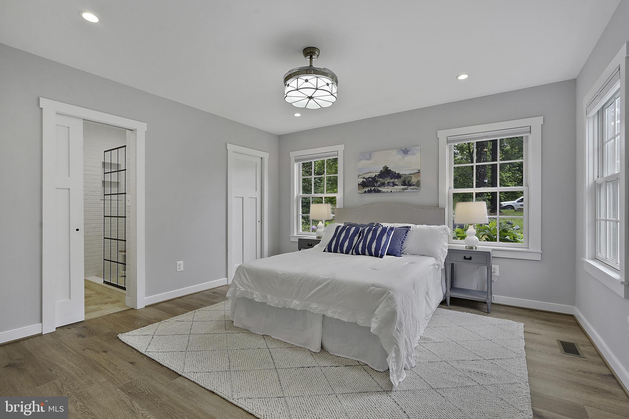 39913 Thomas Mill Road Leesburg, VA 20175 - Photo 9 of 46 a bedroom with a large bed and a chandelier