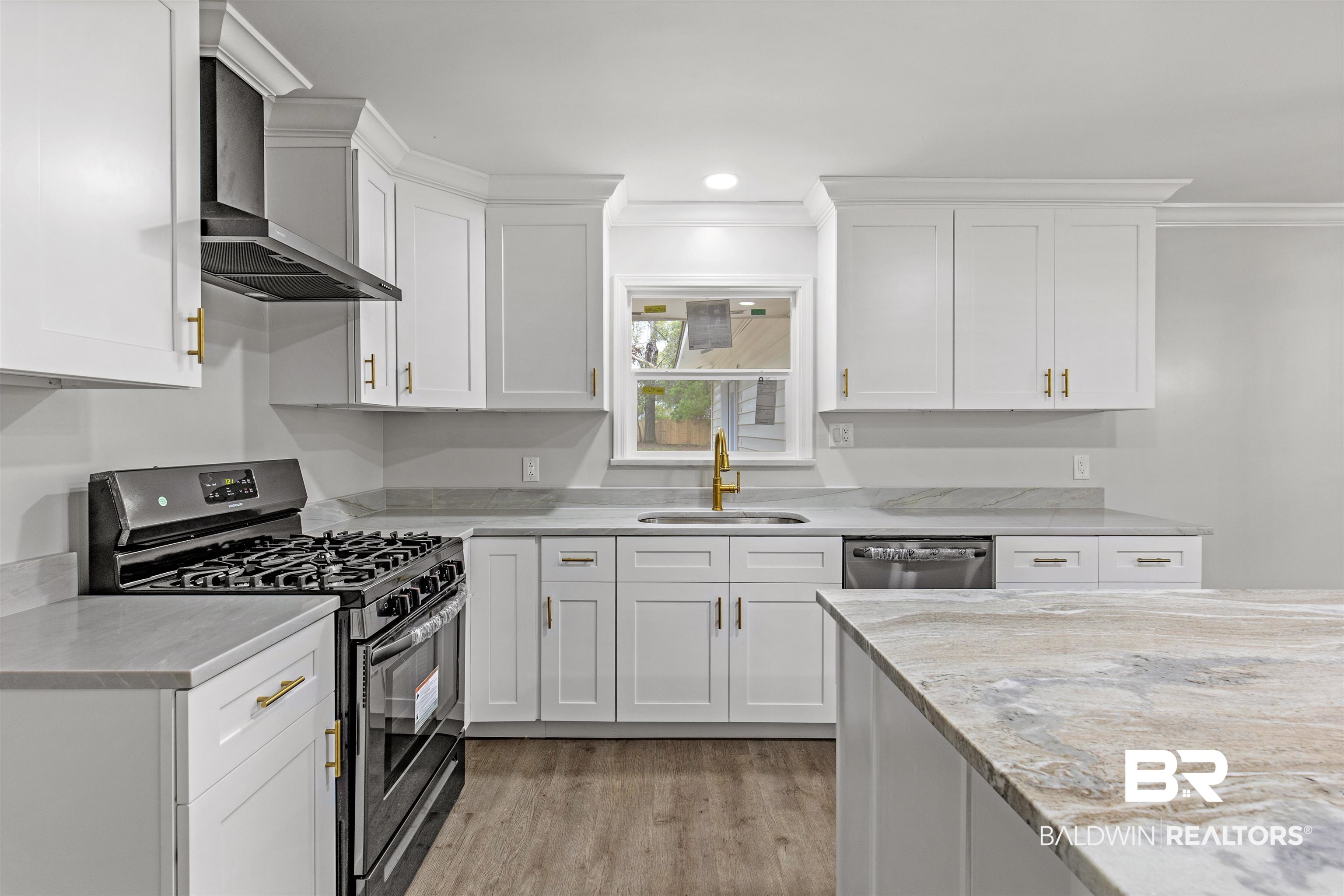 1432 South Polaris Drive Mobile, AL 36693 - Photo 3 of 27 Kitchen featuring stainless steel appliances, crown molding, light wood-style flooring, white cabinets, and wall chimney range hood