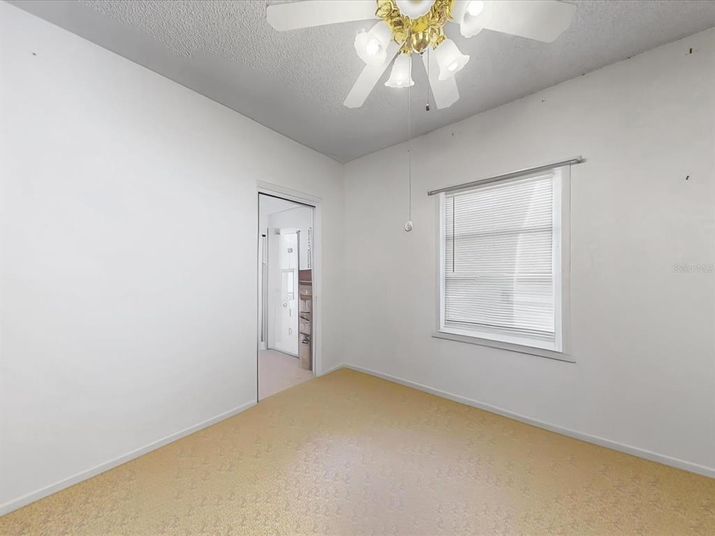 420 Jacks Memorial Road St. Cloud, FL 34769 - Photo 11 of 37 an empty room with a chandelier fan and windows