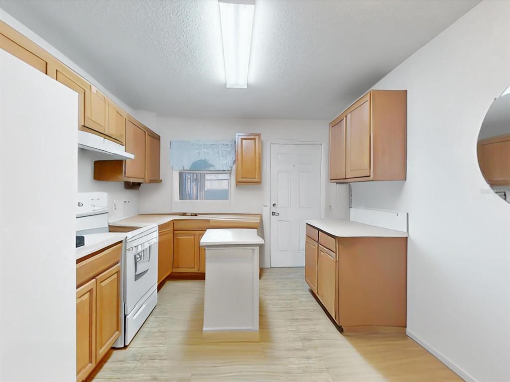420 Jacks Memorial Road St. Cloud, FL 34769 - Photo 19 of 37 a kitchen with stainless steel appliances a sink stove and cabinets
