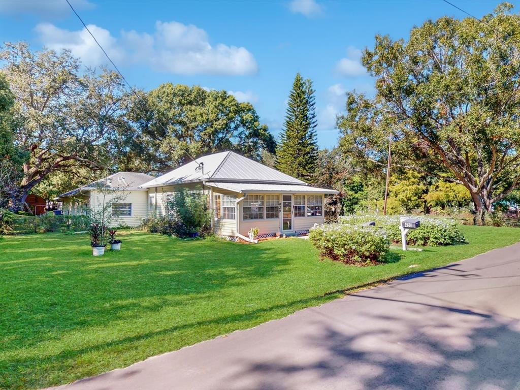420 Jacks Memorial Road St. Cloud, FL 34769 - Photo 2 of 37 a yellow and red house with a garden