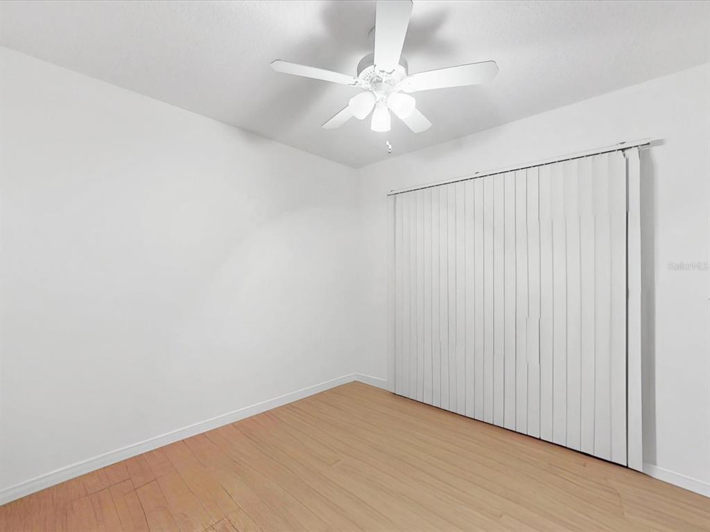 420 Jacks Memorial Road St. Cloud, FL 34769 - Photo 21 of 37 an empty room with a ceiling fan and wooden floor
