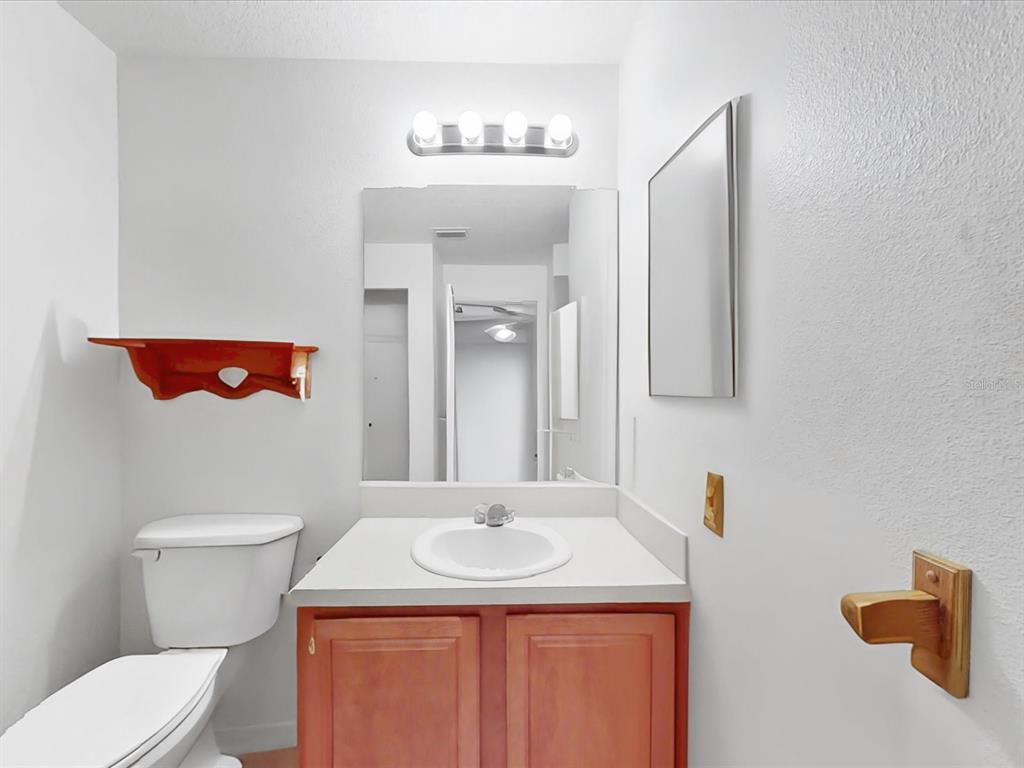 420 Jacks Memorial Road St. Cloud, FL 34769 - Photo 23 of 37 a bathroom with a sink a toilet and a mirror