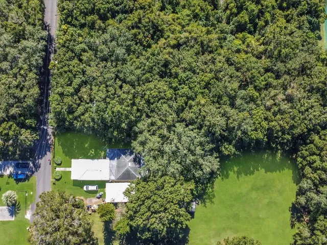 a aerial view of a house with a yard table and chairs