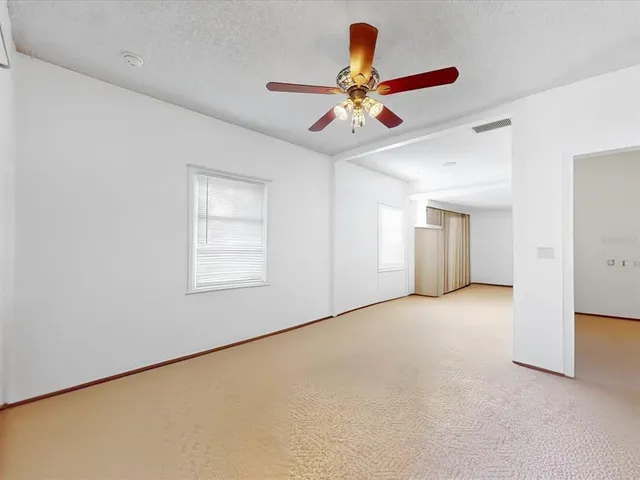 a view of a livingroom with a ceiling fan and window