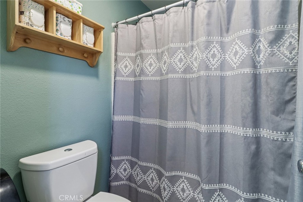 31461 Congressional Drive Temecula, CA 92591 - Photo 31 of 69 a bathroom with a toilet and a shower curtain