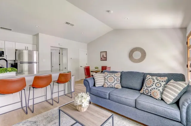 a living room with furniture kitchen and a table