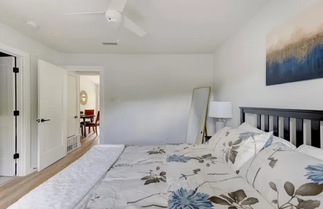 a bedroom with a bed and a lamp on dresser