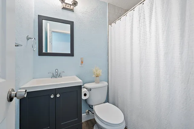 a bathroom with a toilet a sink and a mirror