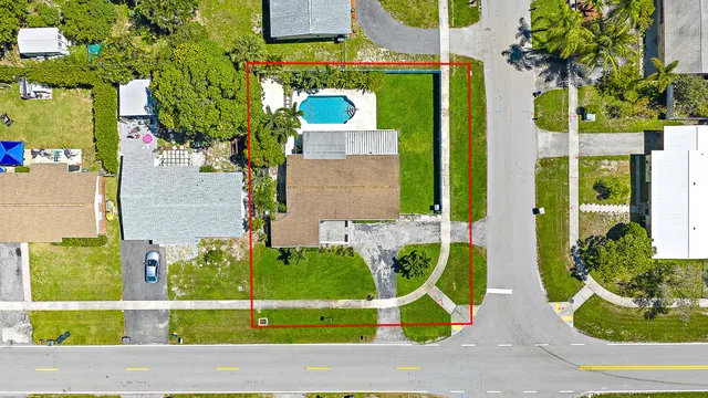 an aerial view of a house with a garden and lake view