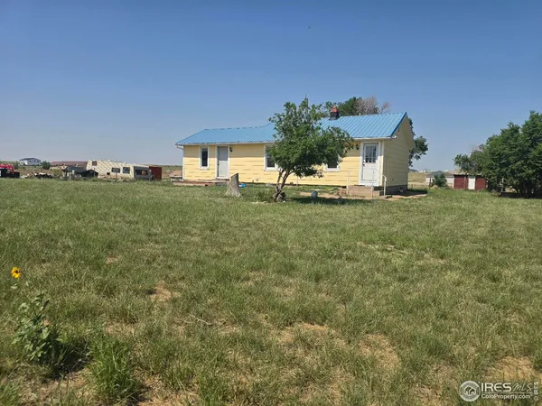 a view of a house with a yard and table