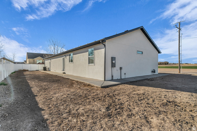 520 East 450th Street North Delta, UT 84624 - Photo 6 of 48 View of side of property featuring stucco siding, a fenced backyard, and a patio area