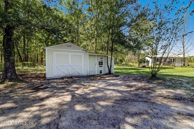 a view of a house with a yard and tree