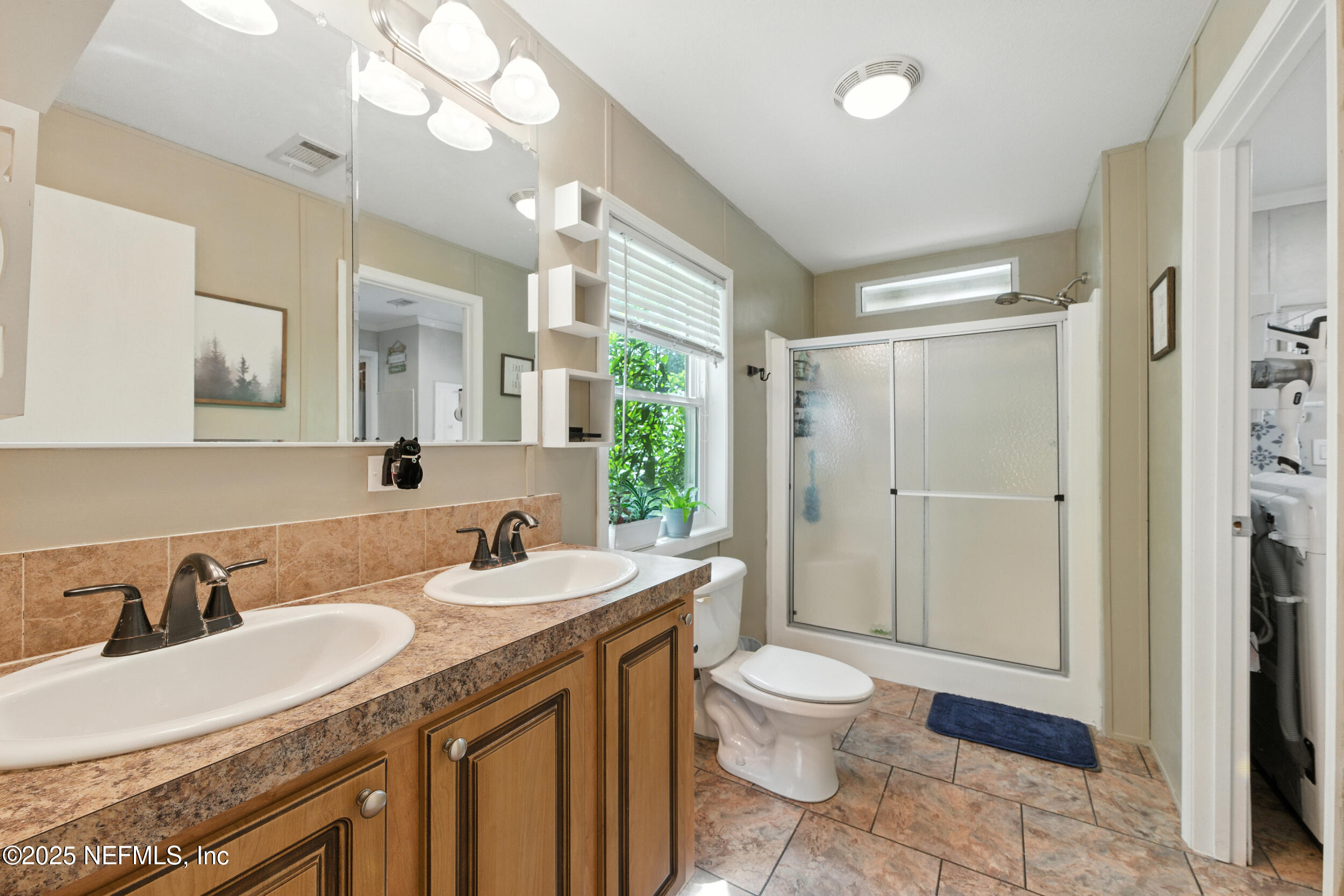 44586 Maplewood Court Callahan, FL 32011 - Photo 10 of 20 a bathroom with a granite countertop double vanity sink a mirror and a toilet