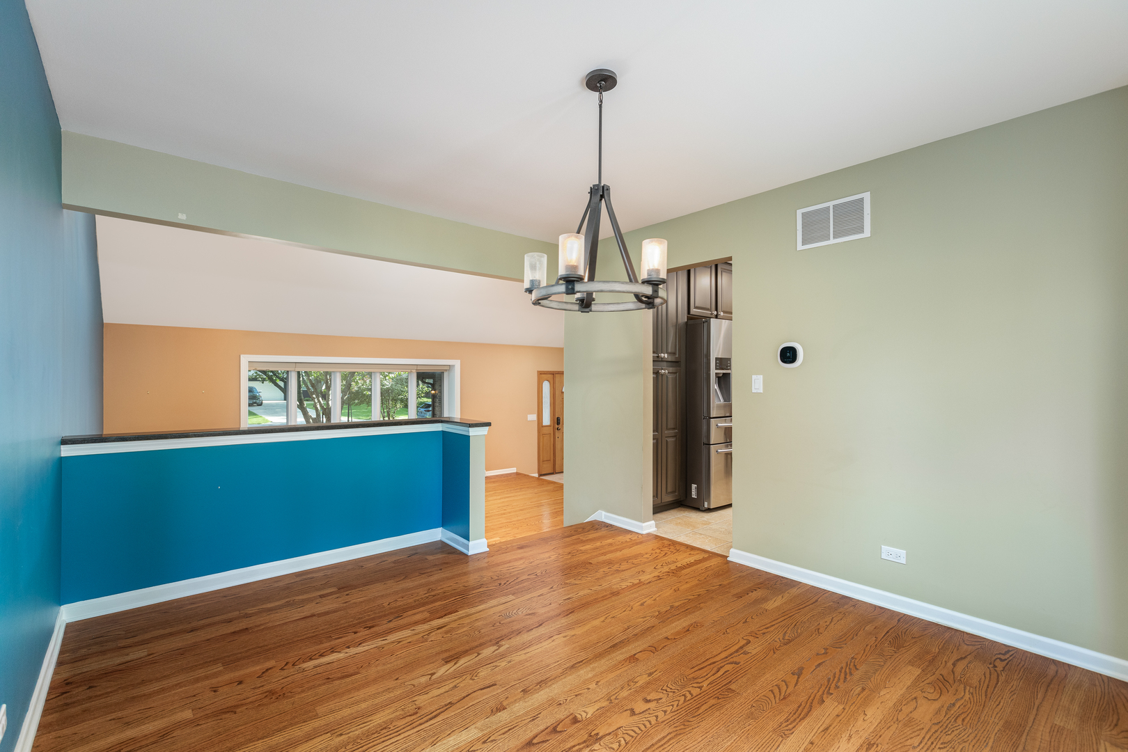 729 East Bauer Road Naperville, IL 60563 - Photo 19 of 57 a view of a room with wooden floor a chandelier and a window