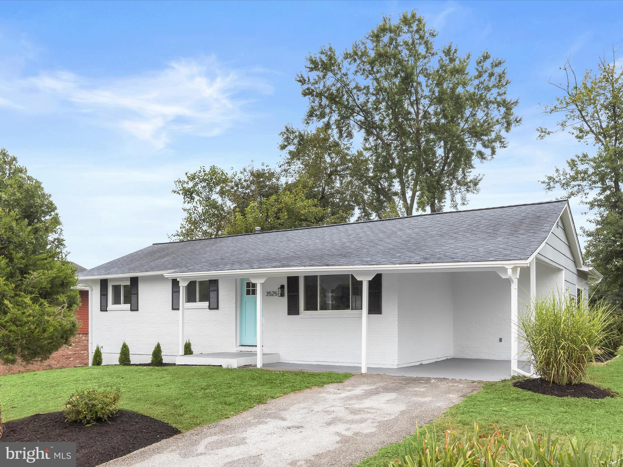 a front view of a house with a yard and potted plants