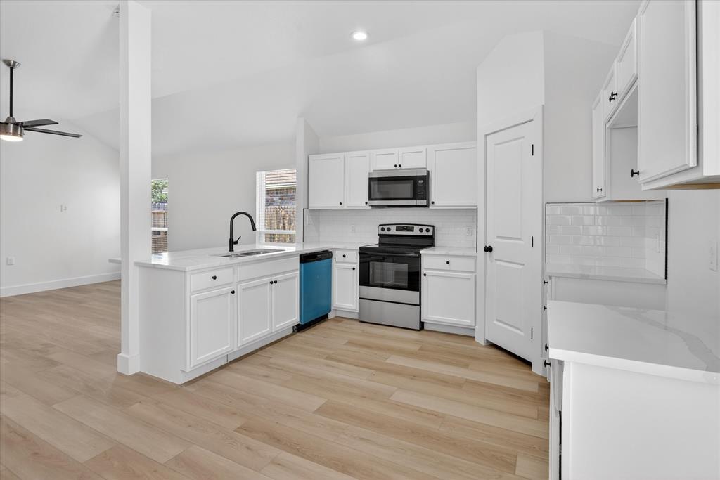 6021 Hartman Road Forest Hill, TX 76119 - Photo 12 of 27 a kitchen with stainless steel appliances a sink cabinets and wooden floor