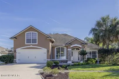 a front view of a house with a garden and plants