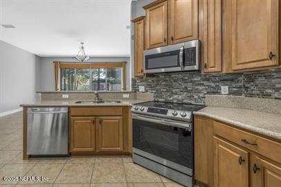 32330 Sunny Parke Drive Fernandina Beach, FL 32034 - Photo 18 of 38 a kitchen with stainless steel appliances granite countertop a stove microwave and cabinets