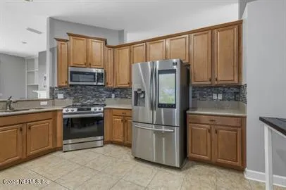 a kitchen with granite countertop a refrigerator stove and sink