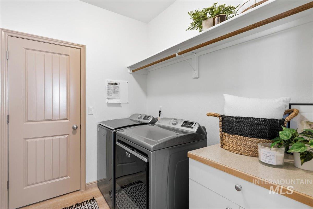 1183 North Buffalo Way Middleton, ID 83644 - Photo 32 of 47 Dedicated laundry area featuring a built-in countertop, white cabinetry, and overhead shelving with a hanging rod