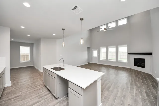a kitchen with a sink chandelier and wooden floor