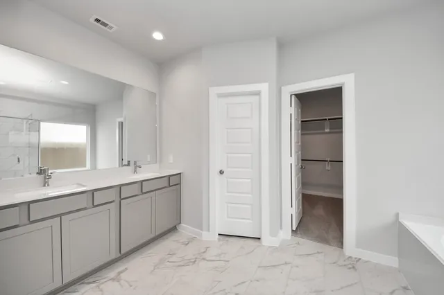 a spacious bathroom with a double vanity sink and a mirror