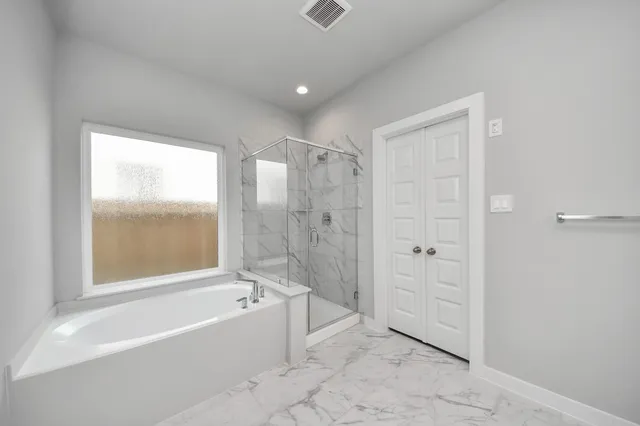 a spacious bathroom with a bathtub and a shower