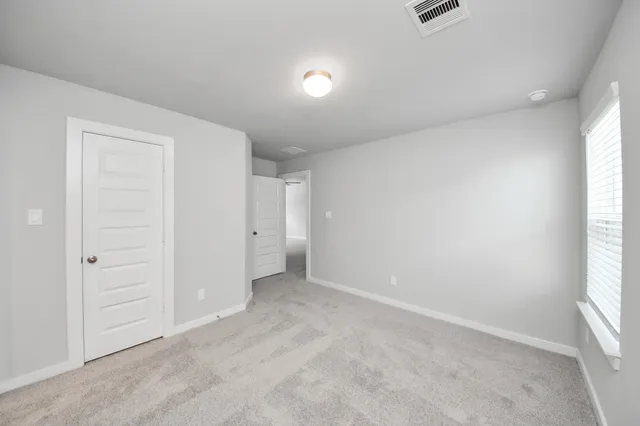 an empty room with windows and closet