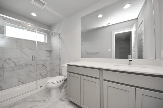 a bathroom with a double vanity sink toilet and shower