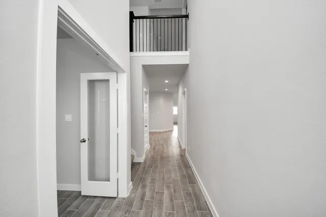 a view of a hallway with wooden floor and staircase