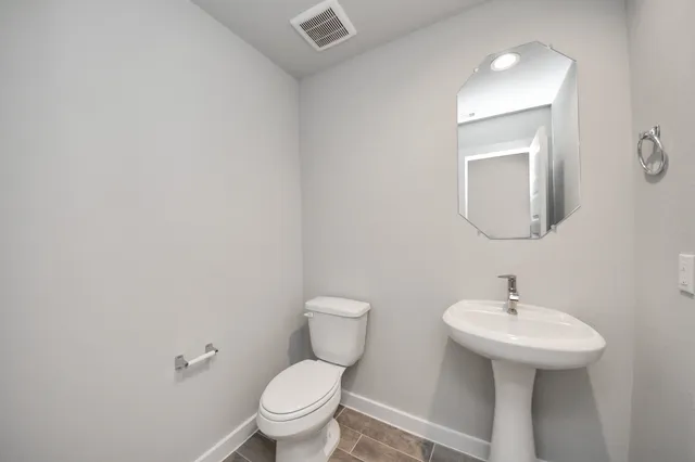 a bathroom with a toilet a sink and mirror