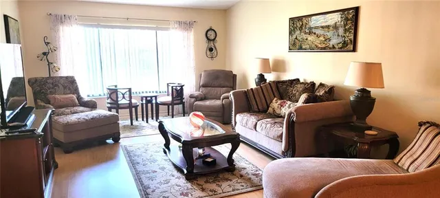 a living room with furniture a fireplace and a large window