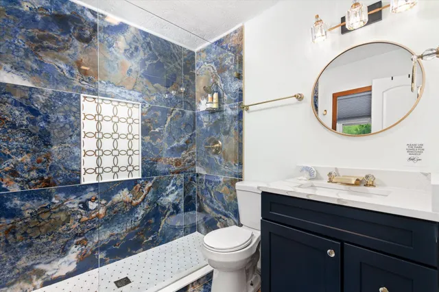 a bathroom with a toilet a sink and a mirror