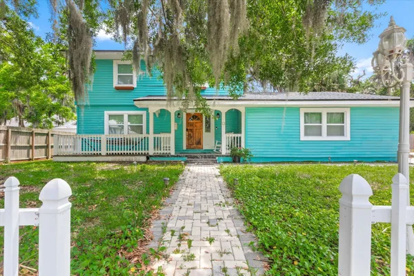 a front view of a house with a yard and trees