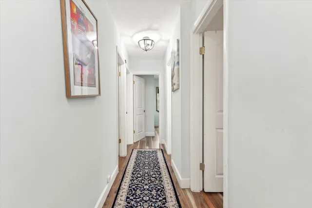 a view of a hallway with wooden floor and entryway